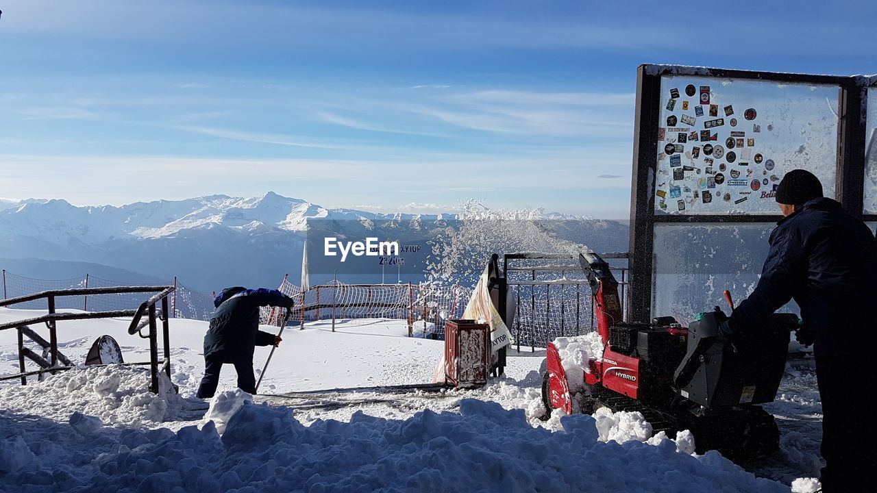 PEOPLE ON SNOWCAPPED MOUNTAINS AGAINST SKY