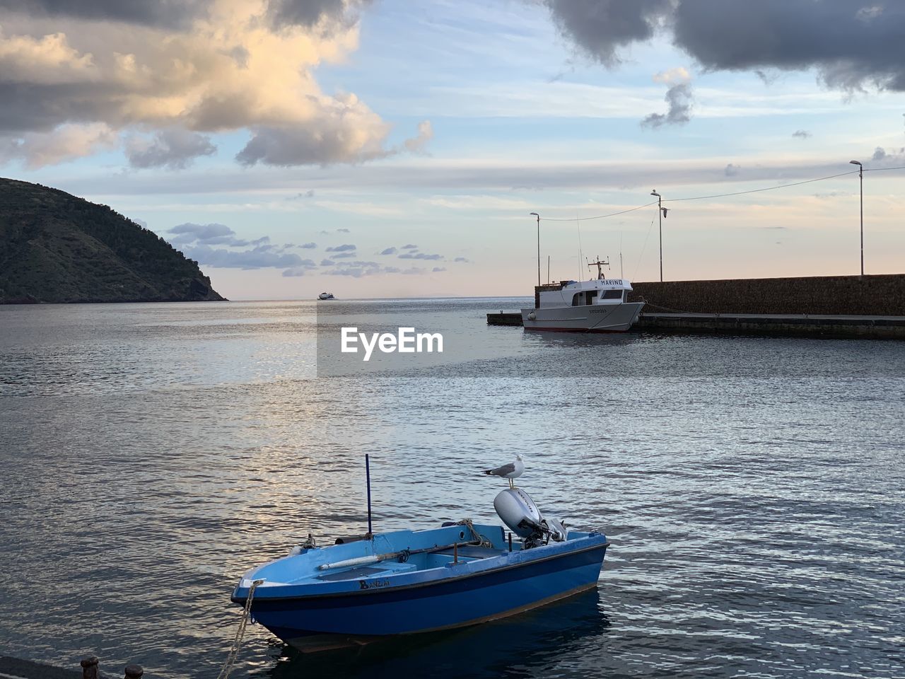 BOAT MOORED ON SEA AGAINST SKY