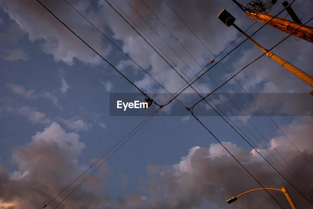 Low angle view of electricity pylons against sky