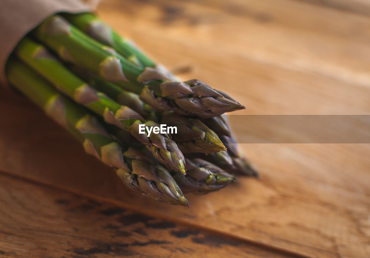 Close-up of fresh green asparagus on wooden background