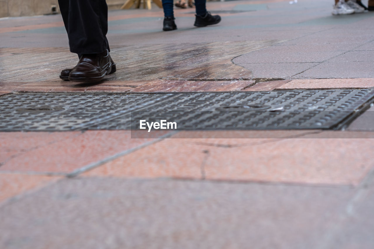 LOW SECTION OF PEOPLE WALKING ON STREET