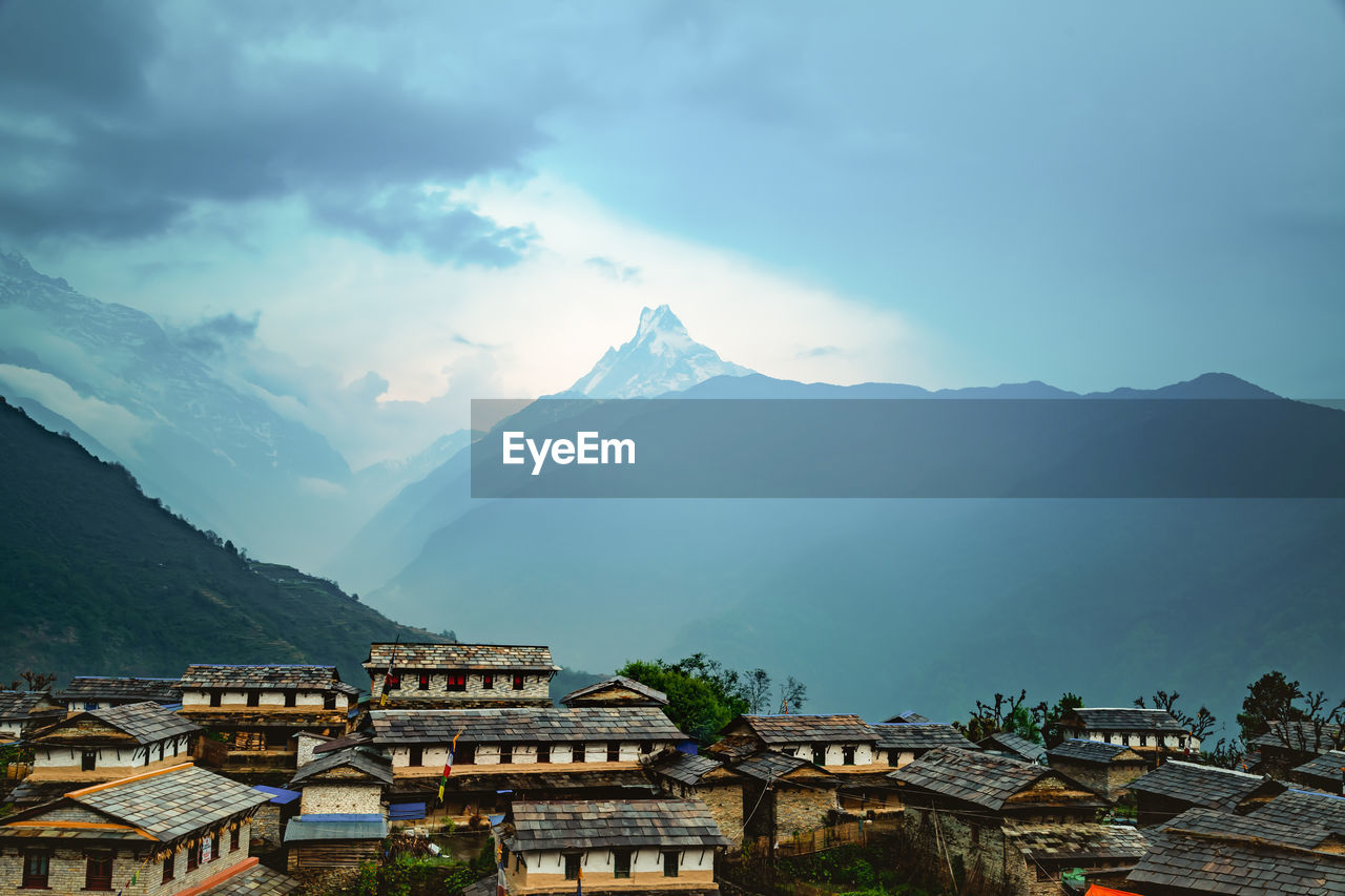 HOUSES ON MOUNTAIN AGAINST SKY