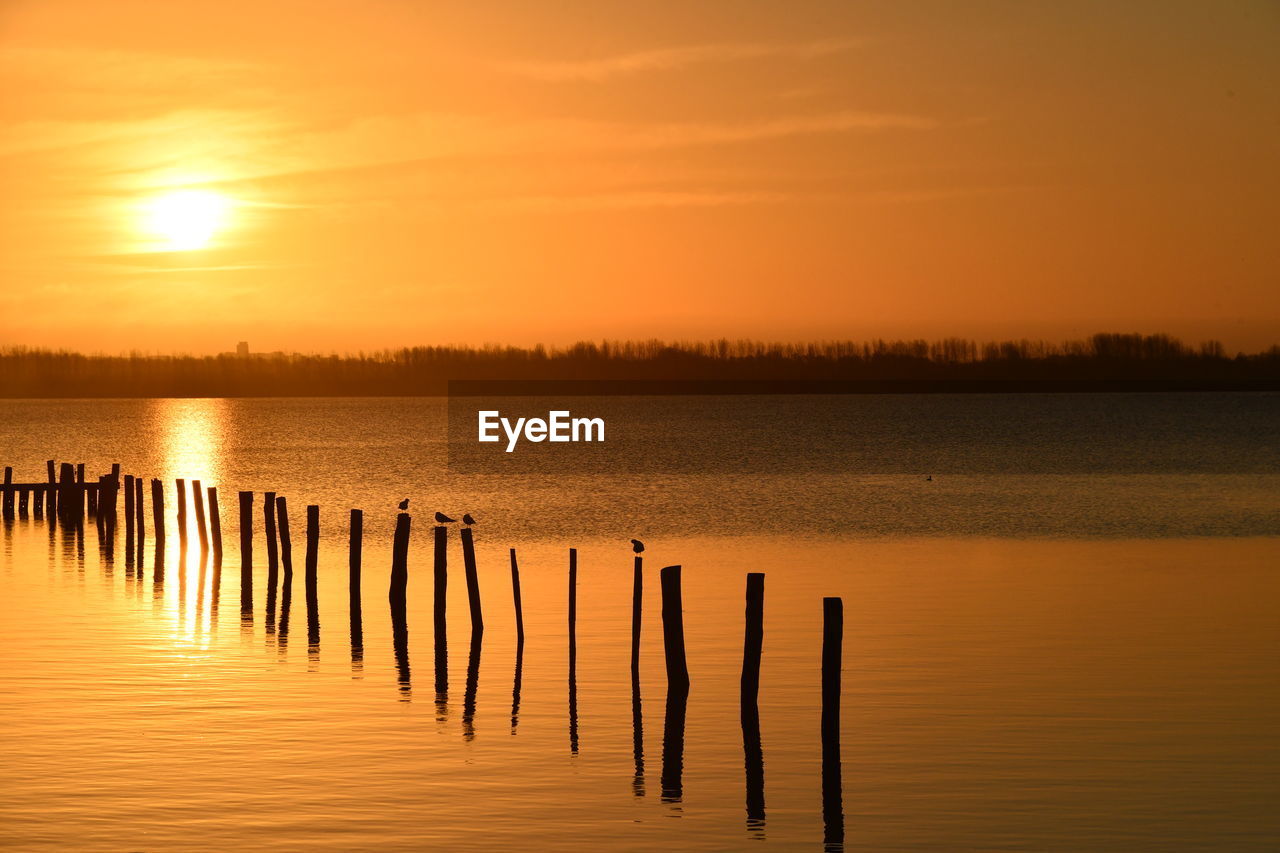 Scenic view of lake against sky during sunset