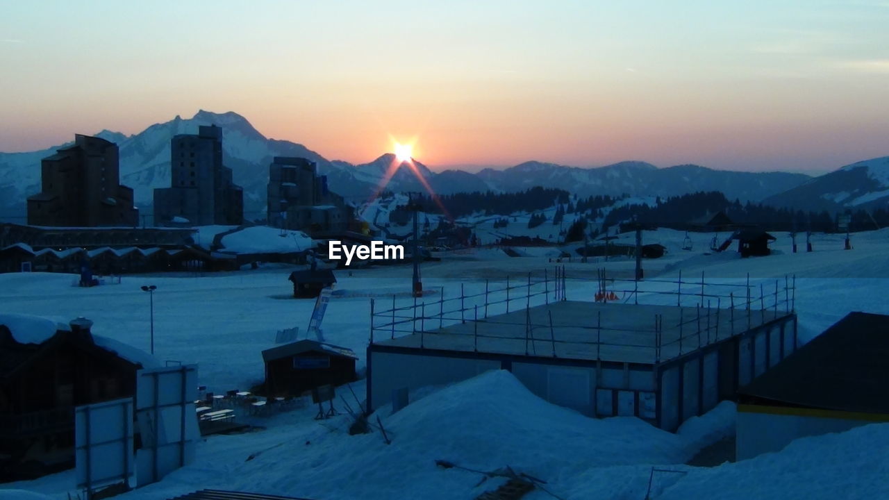 Scenic view of frozen lake against sky during sunset