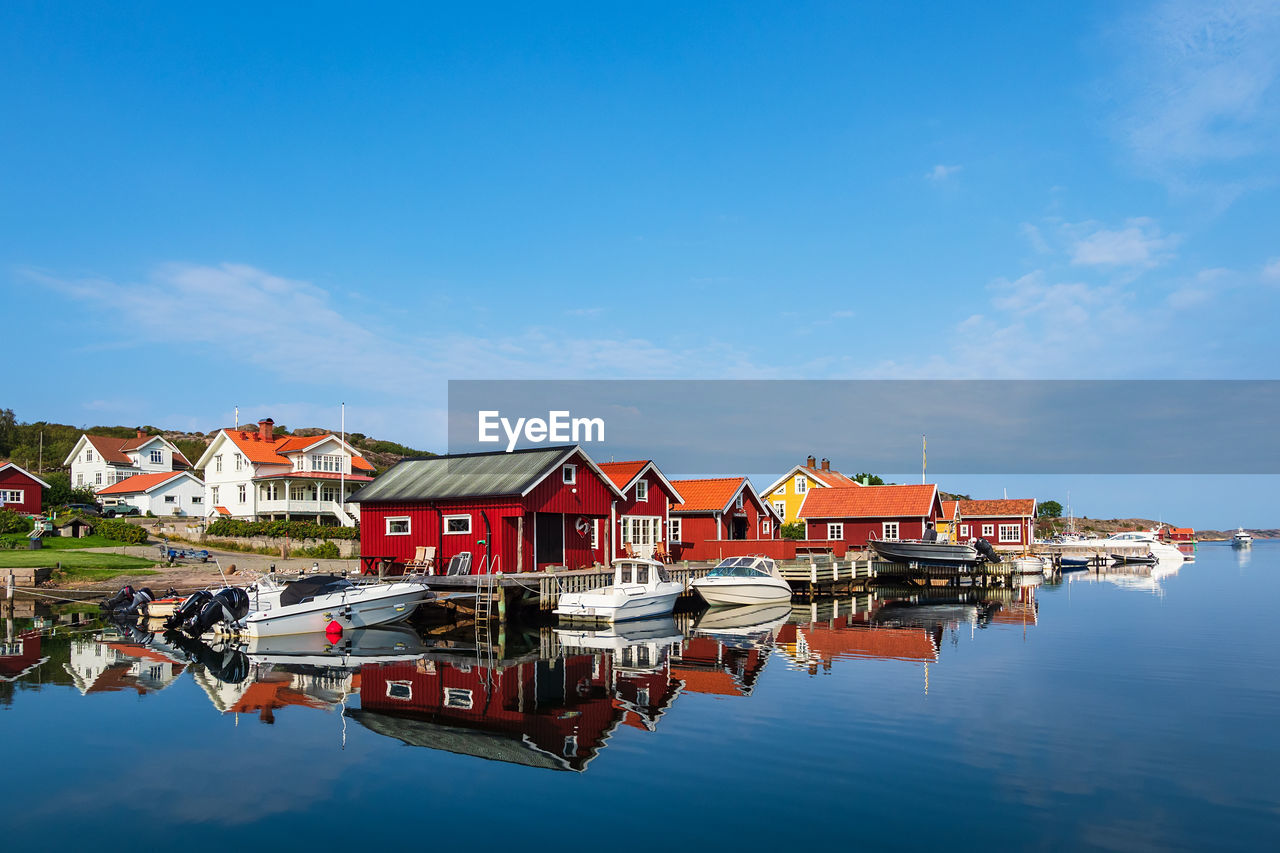 HOUSES BY LAKE AGAINST BLUE SKY