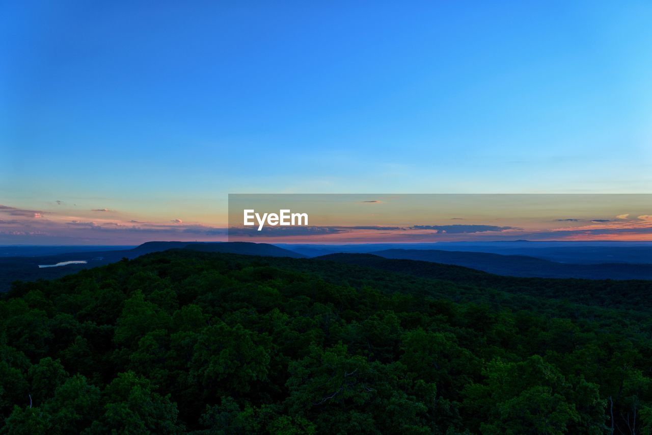 Scenic view of silhouette landscape against blue sky