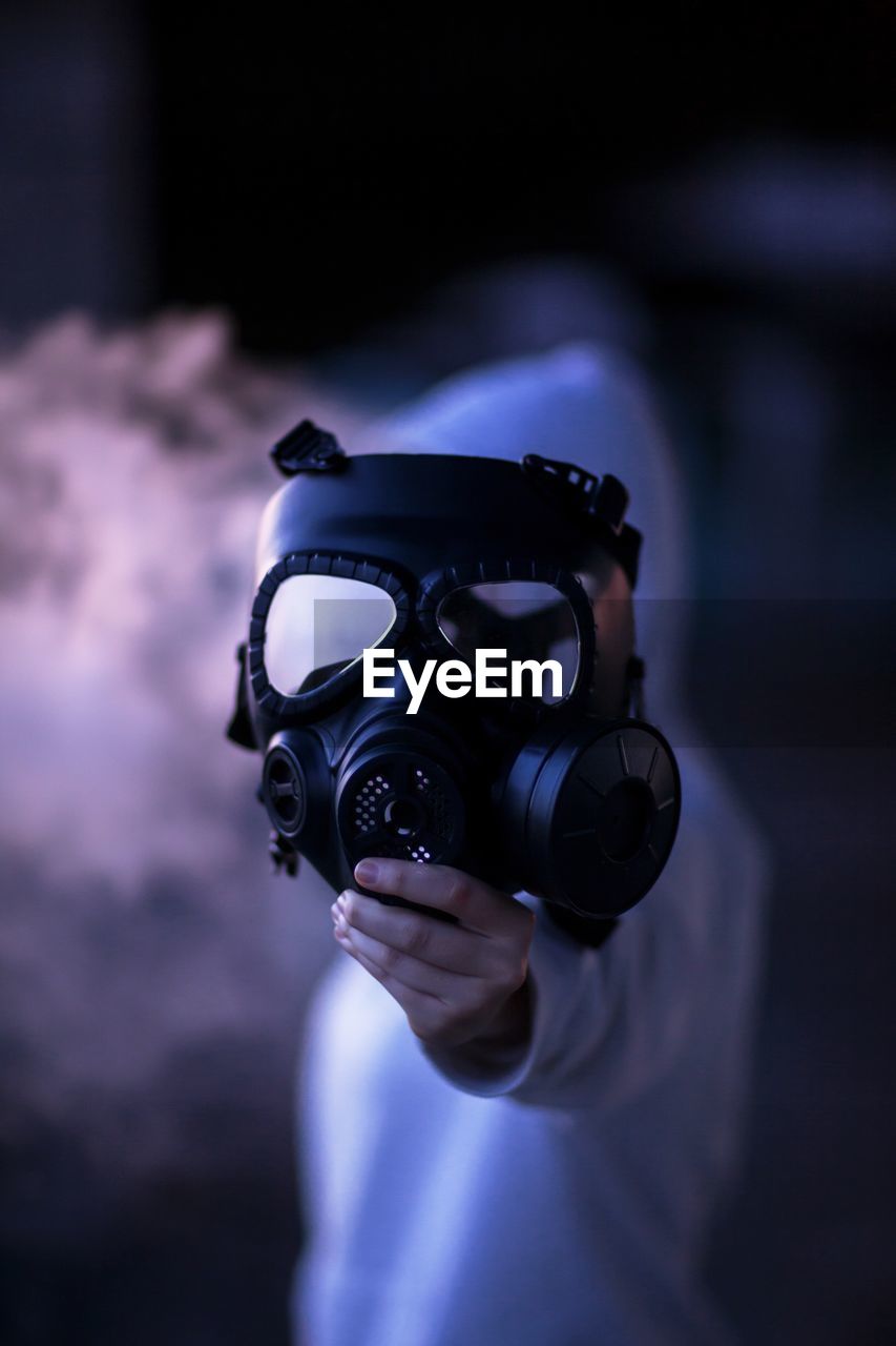 Close-up of man holding gas mask