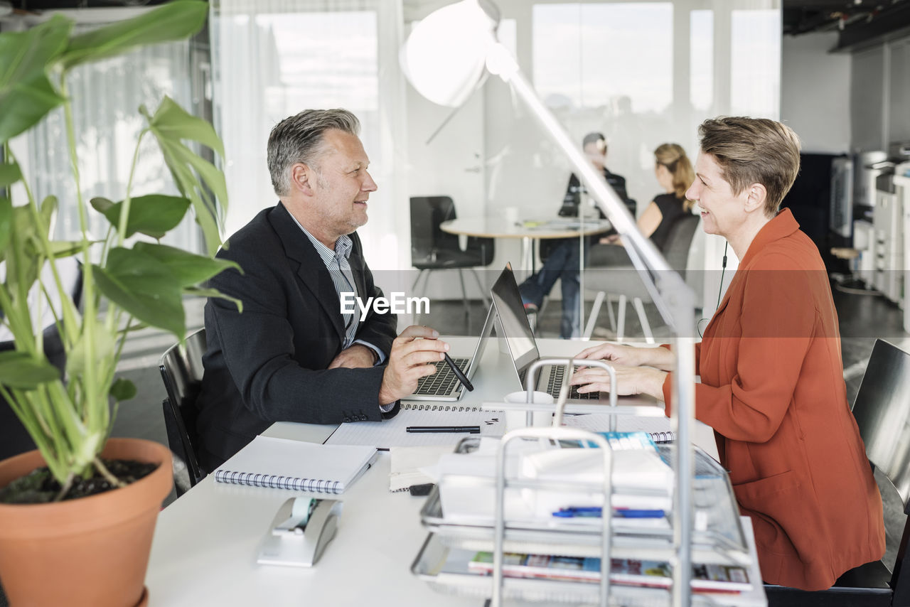 Happy business people having discussion at desk