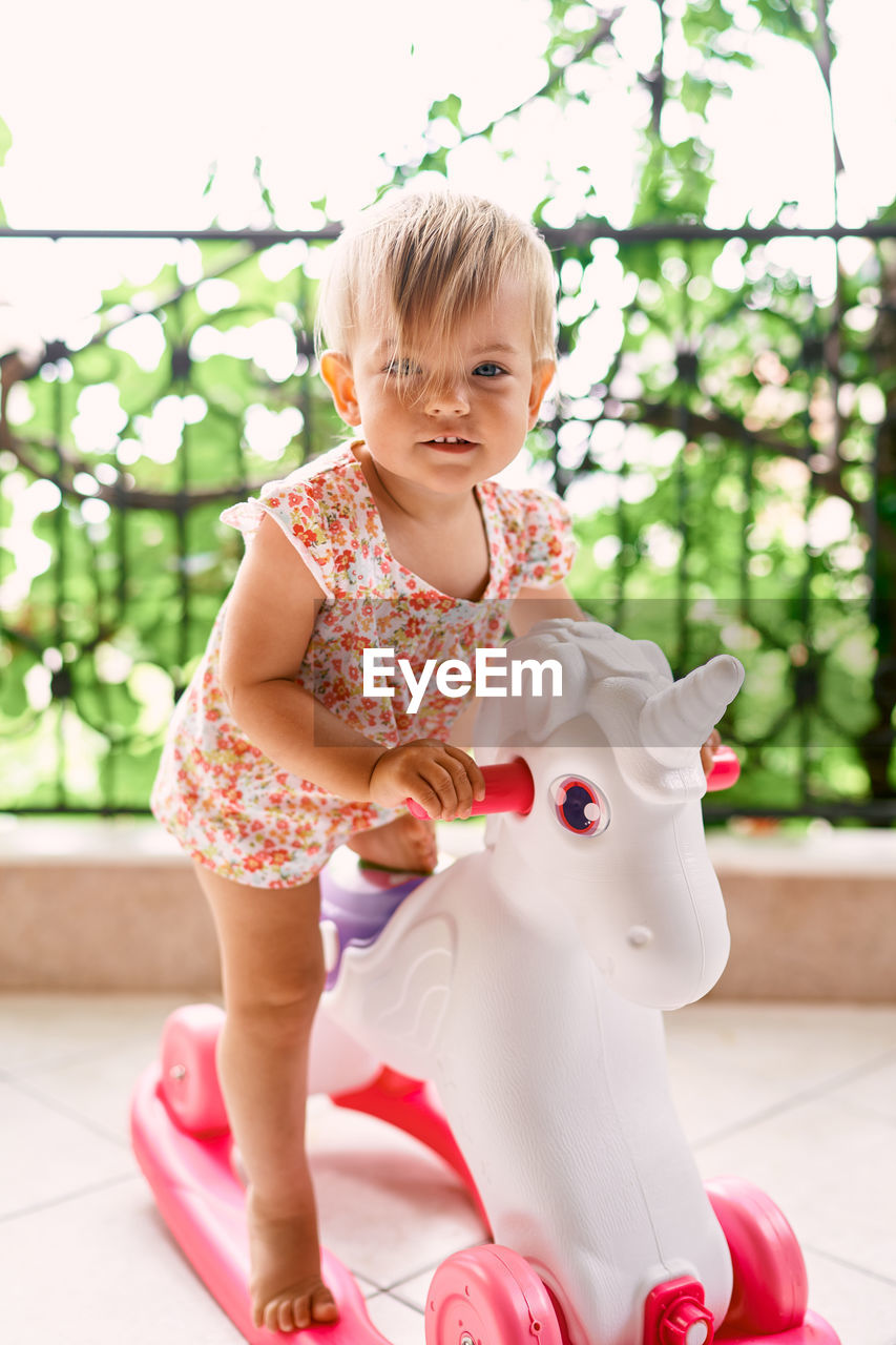 CUTE GIRL WITH TOY AGAINST TREES