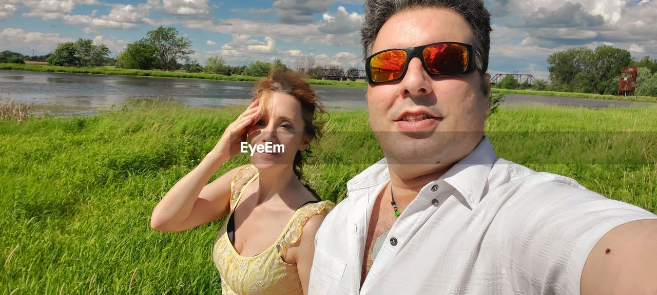 PORTRAIT OF YOUNG MAN WEARING SUNGLASSES AT PARK