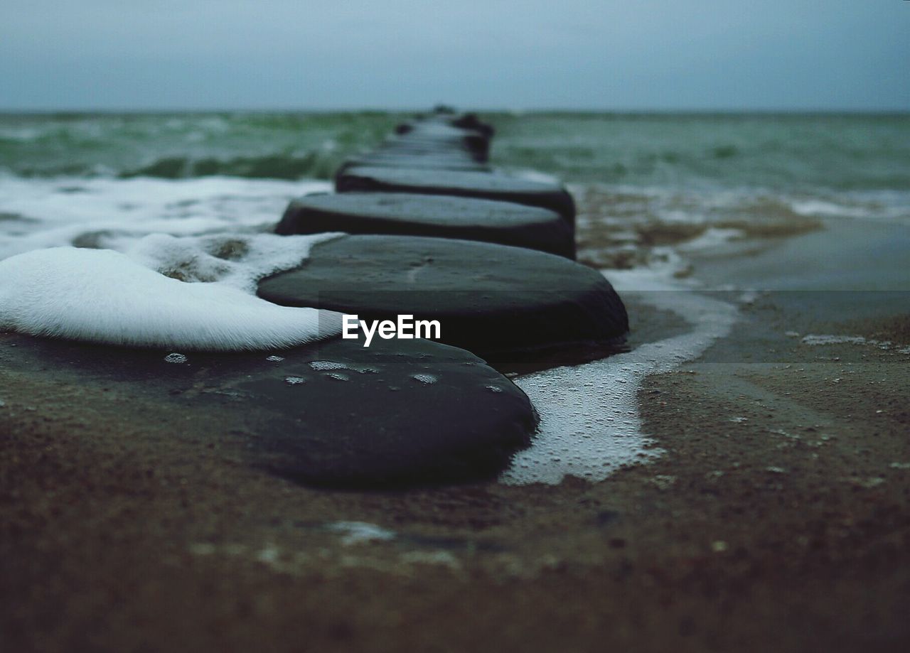 Close-up of wooden posts at sea shore