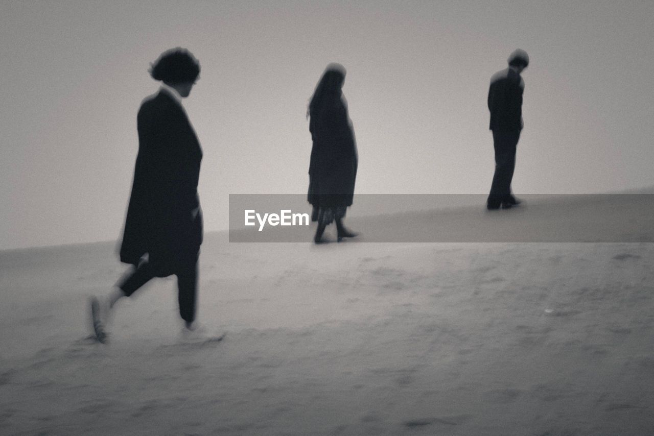 GROUP OF PEOPLE WALKING ON BEACH