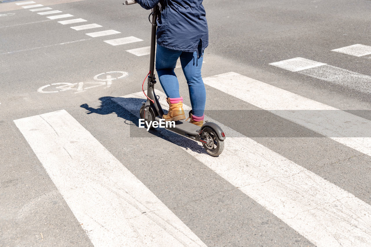 Low section of man riding bicycle on road