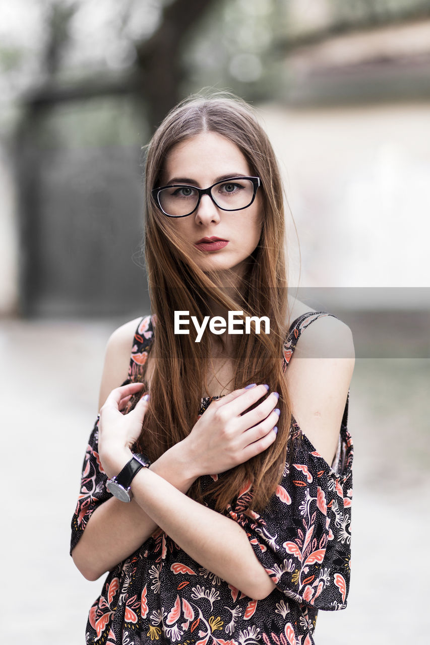 Young brown-haired millennial with glasses and light dress