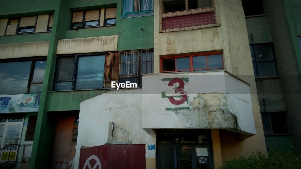 LOW ANGLE VIEW OF BUILDING BY RESIDENTIAL BUILDINGS