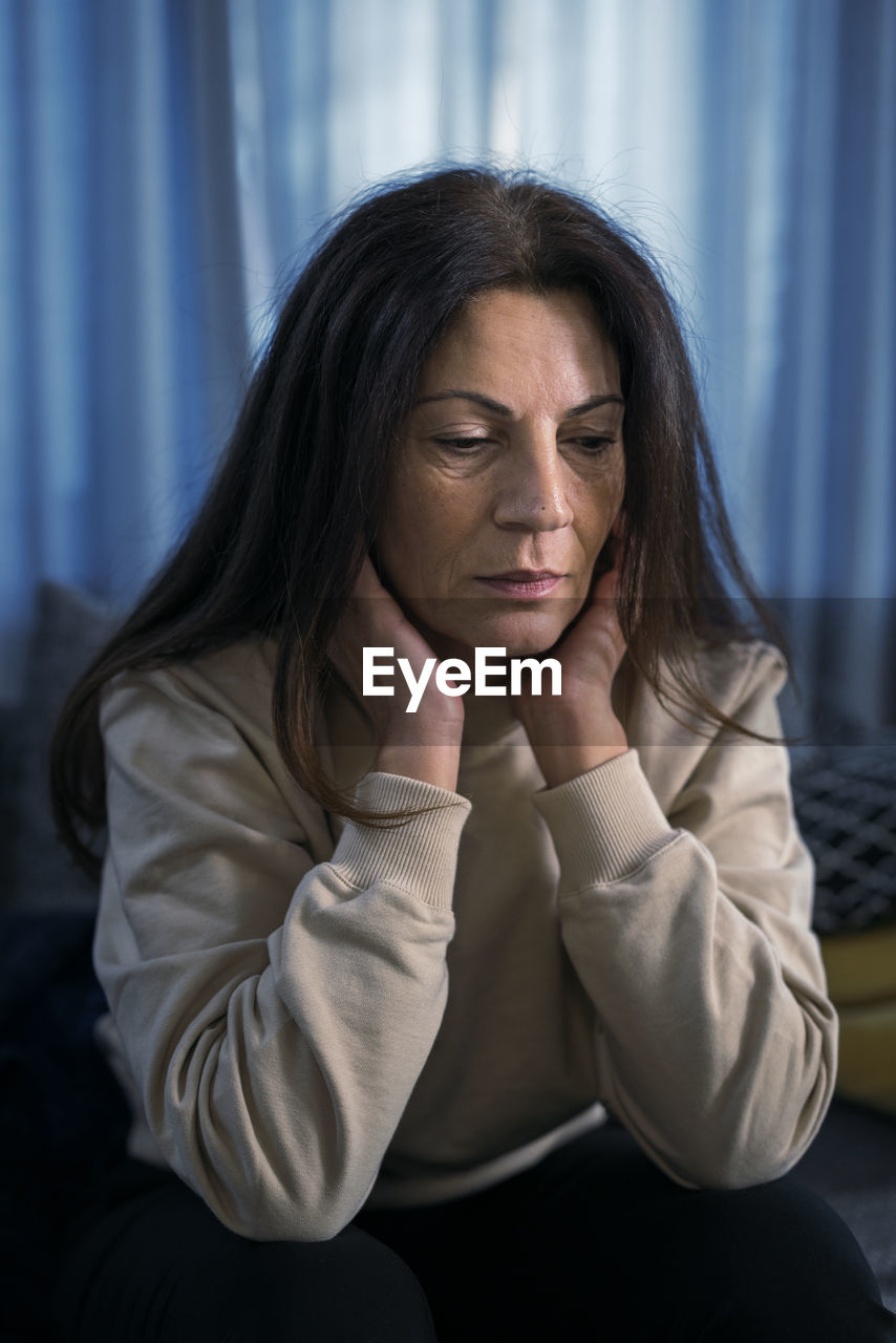 Depressed woman sitting in living room