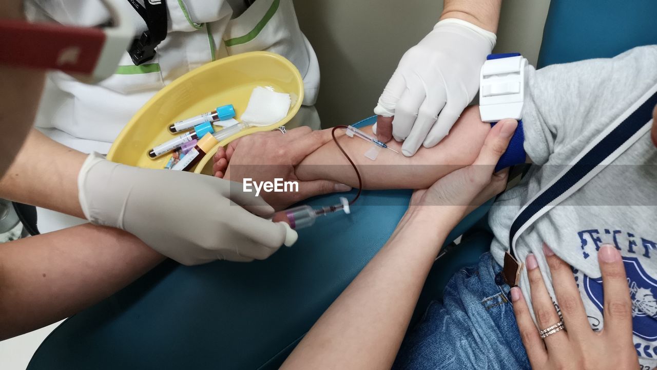 Midsection of doctor giving injection to patient