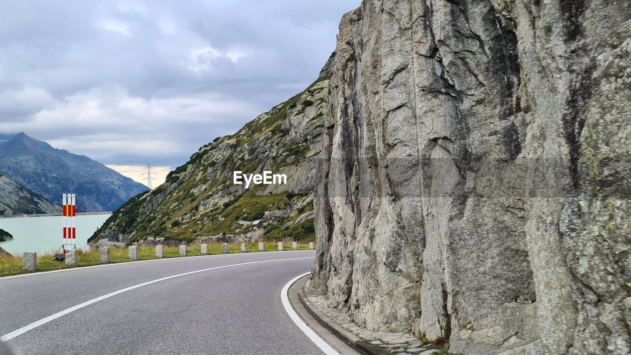 Road leading towards mountains against sky