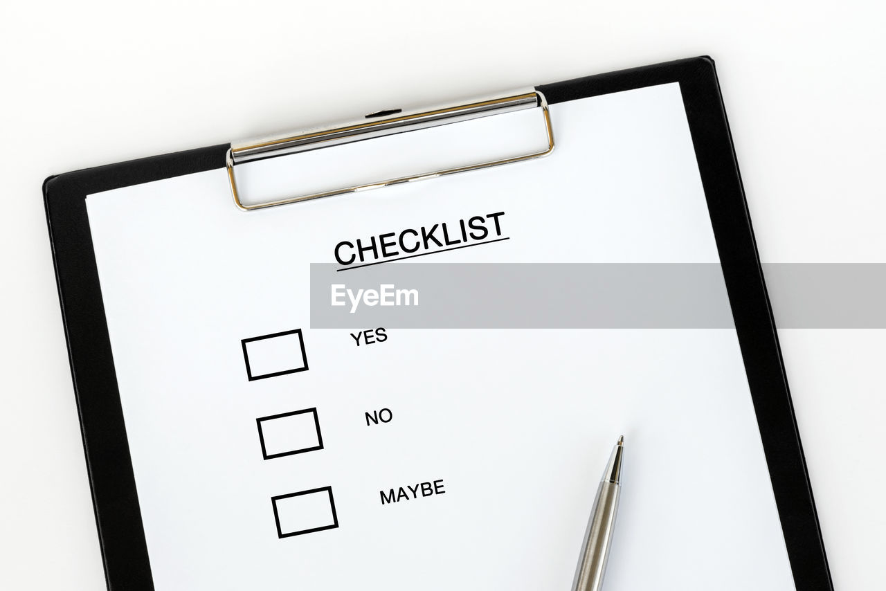 Directly above shot of checklist on clipboard against white background