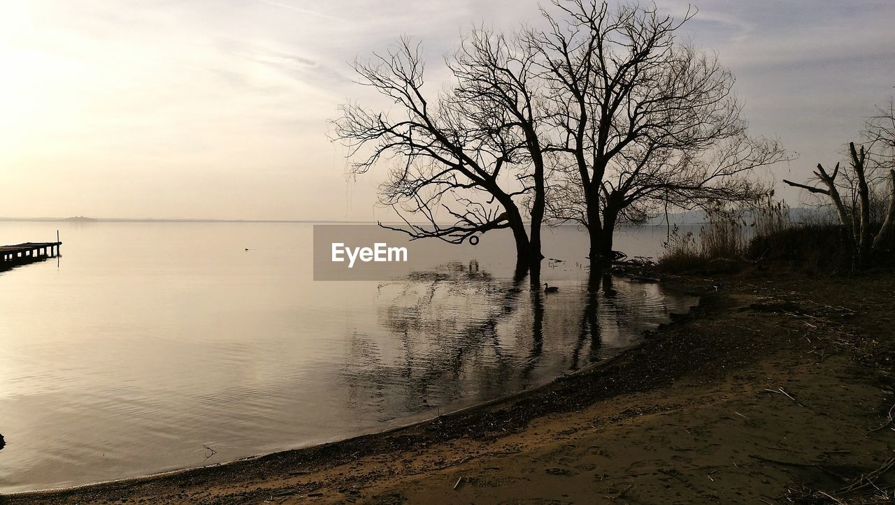 Scenic view of lake against sky at sunset