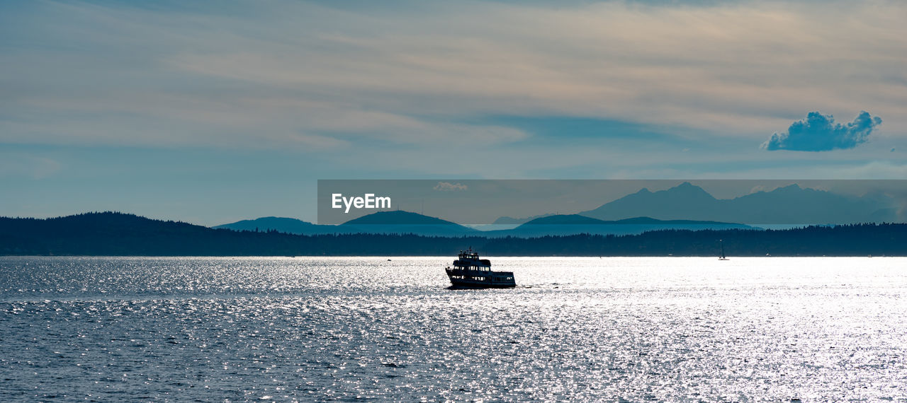 BOAT ON SEA AGAINST MOUNTAINS