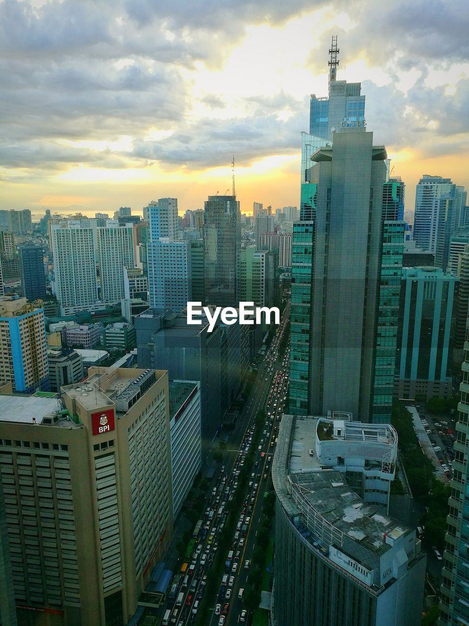 Cityscape against cloudy sky at sunset