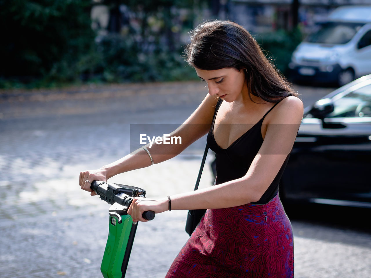 Young woman riding bicycle on road in city