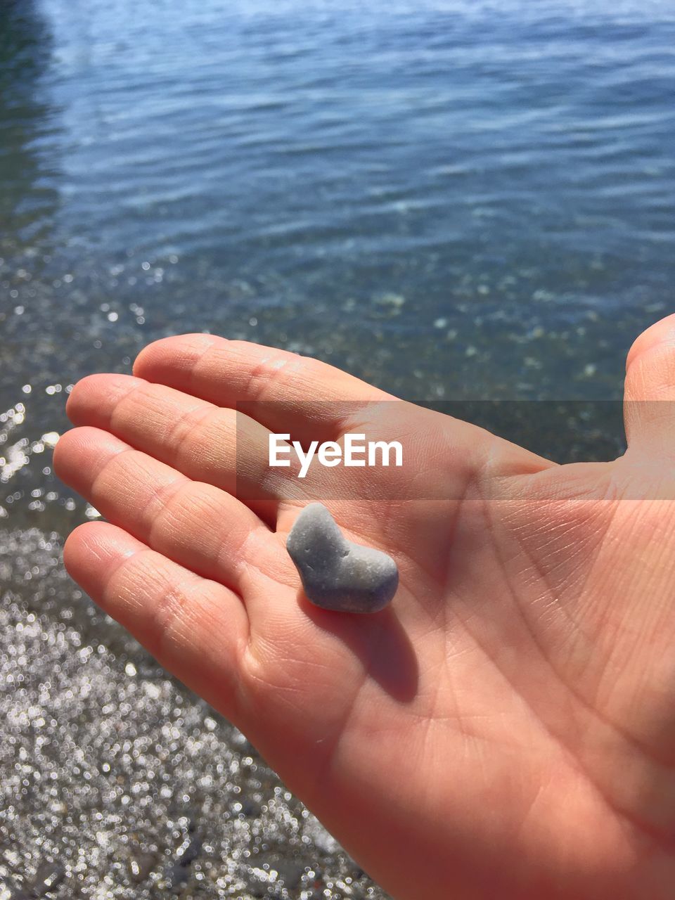 CLOSE-UP OF HAND WITH SEA WATER