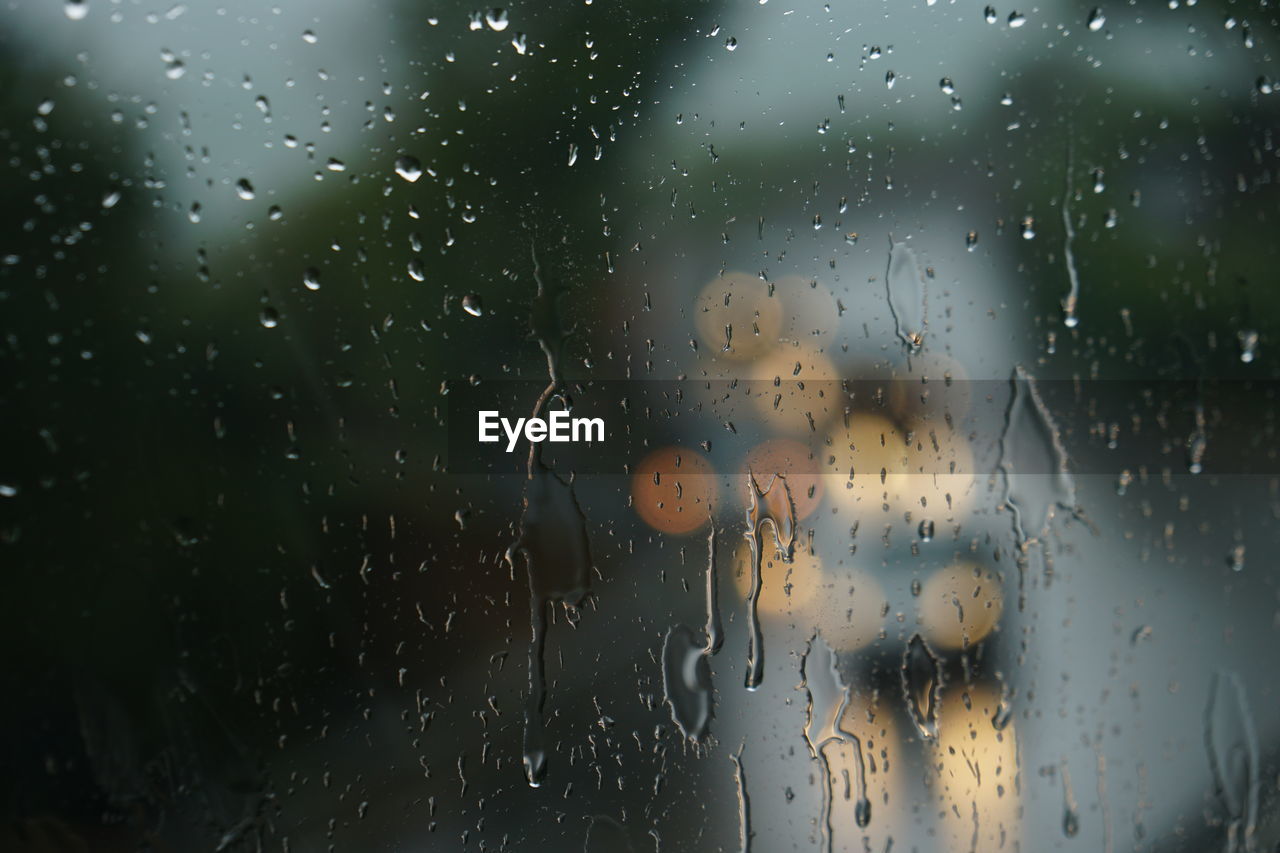 FULL FRAME SHOT OF WET GLASS WINDOW DURING MONSOON