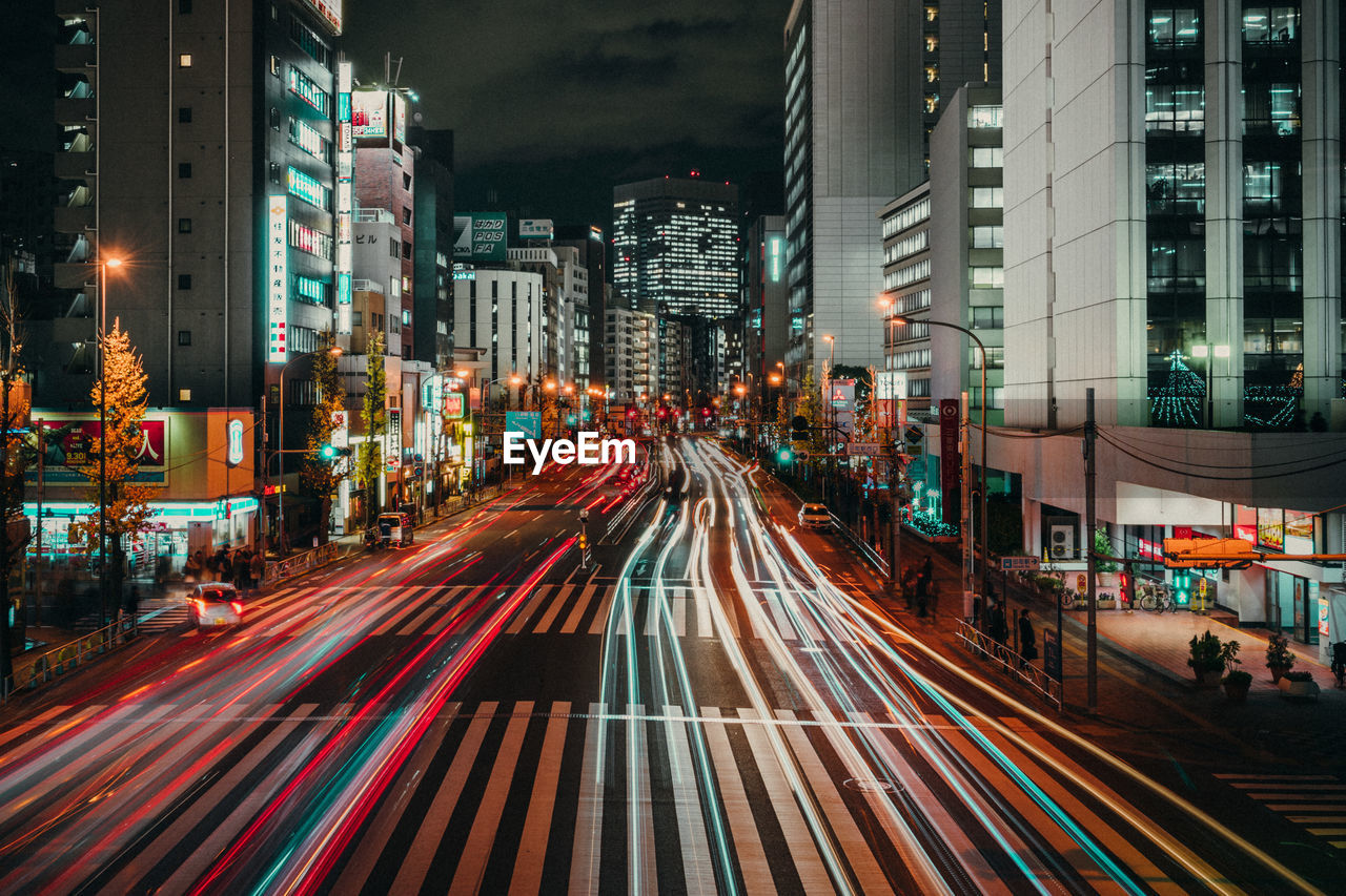 Light trails on road along buildings at night