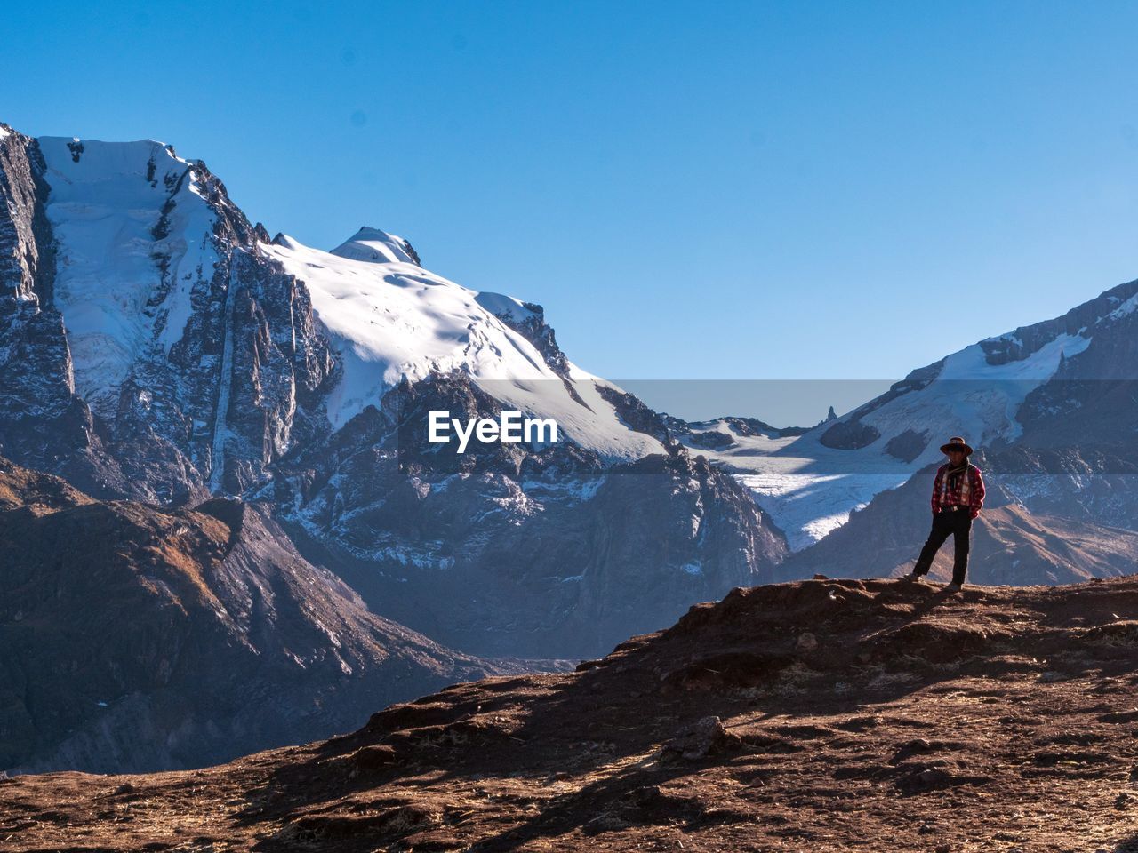 Full length of man standing on rock against mountains and sky