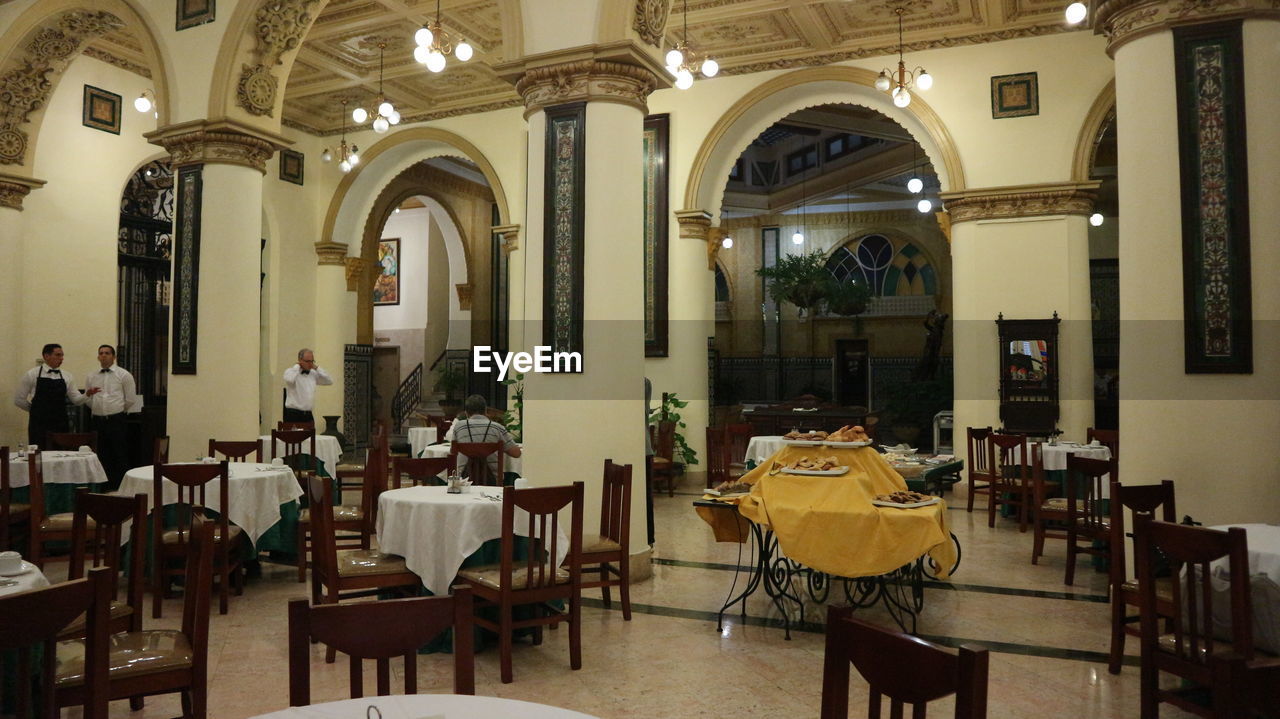 EMPTY CHAIRS AND TABLES IN CAFE