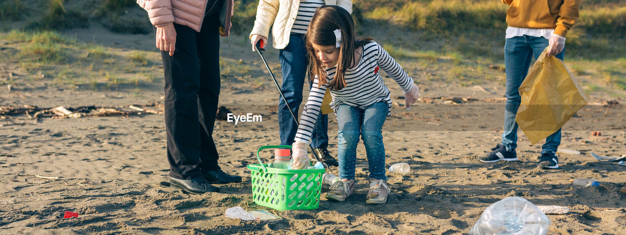 Cute girl collecting garbage outdoors