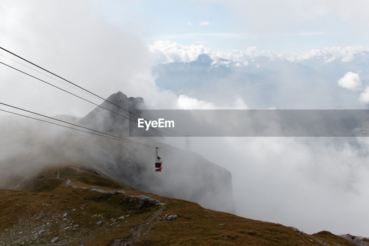 Overhead cable car with mountain in background