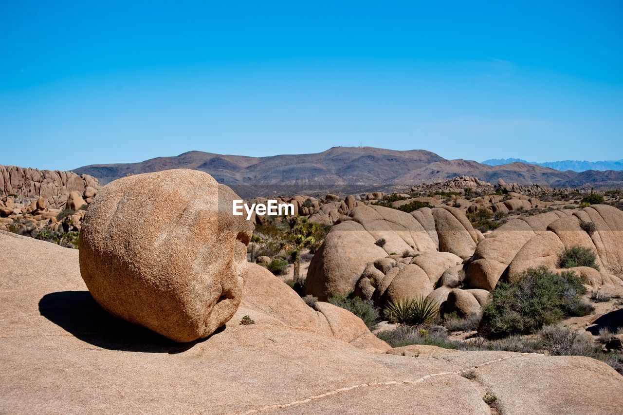 View of rocks on landscape against clear sky