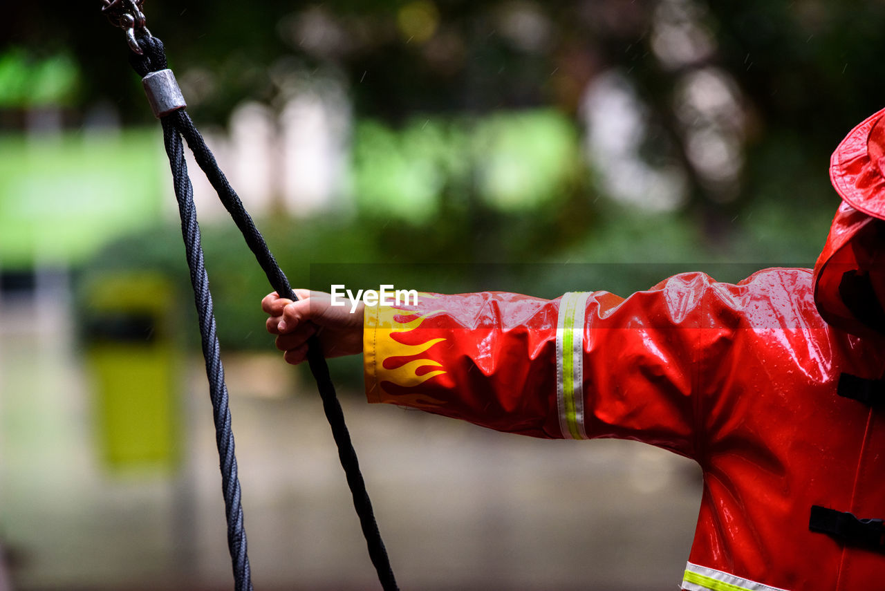 Boy wearing raincoat playing on swing