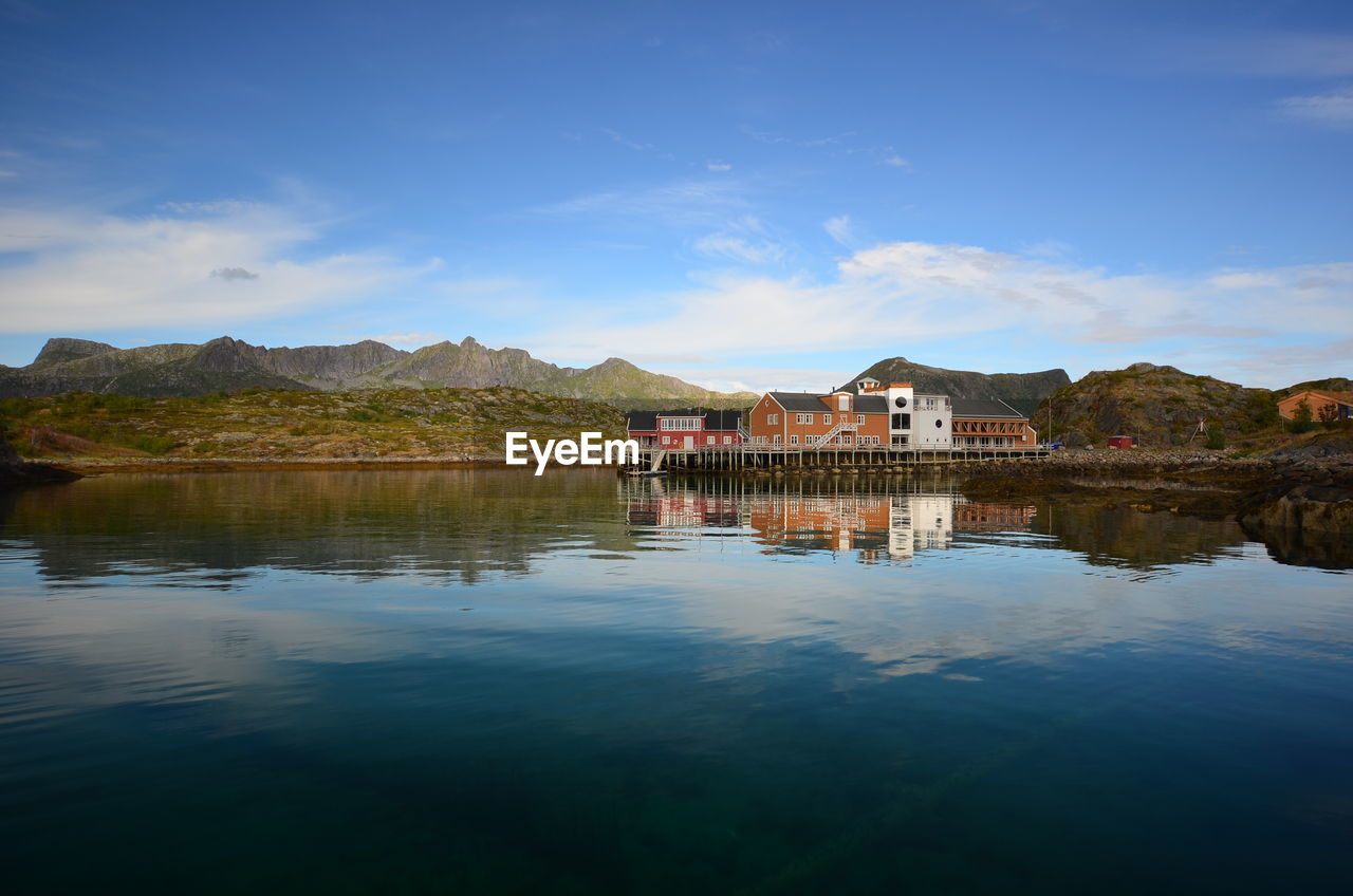 Scenic view of lake by buildings against sky