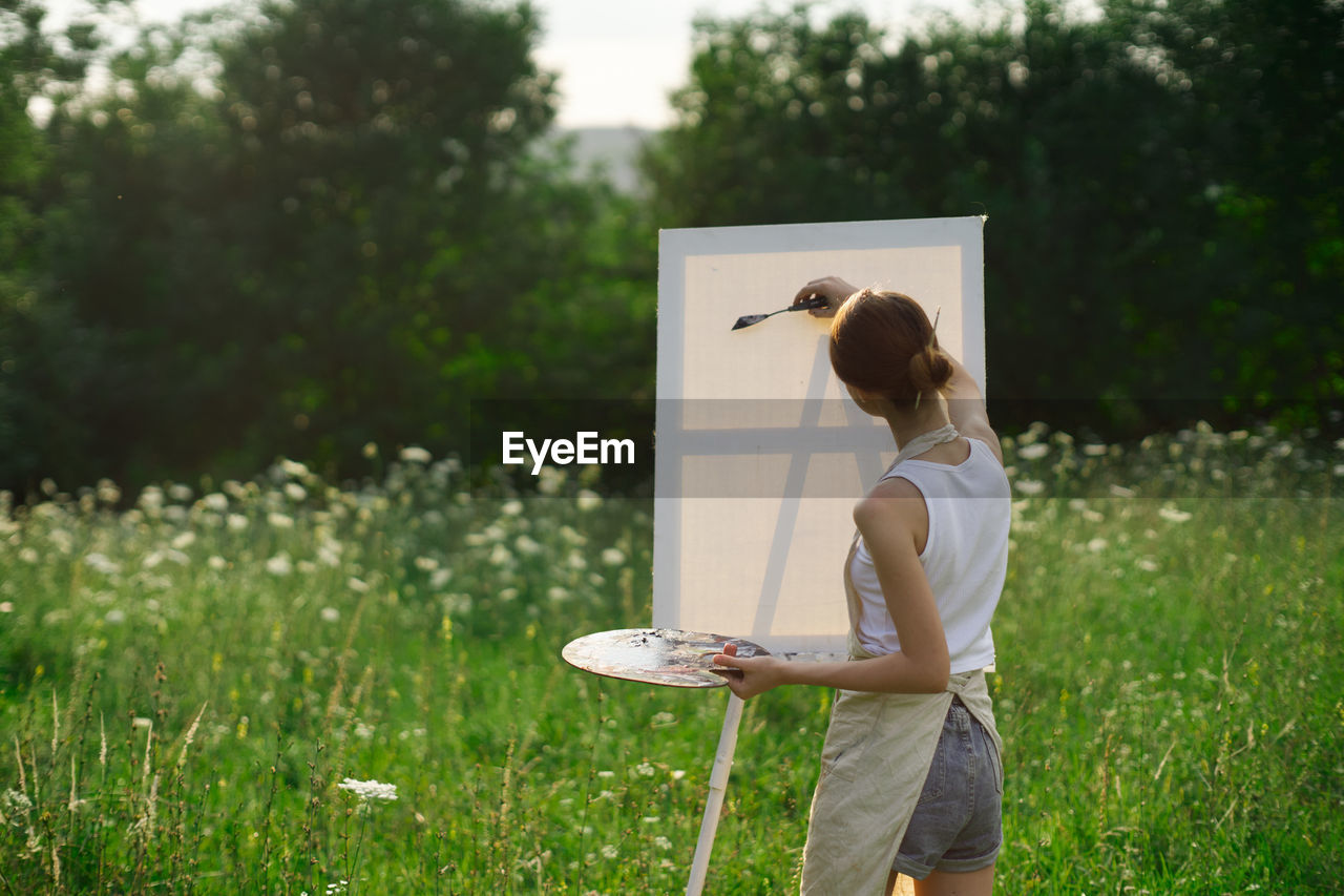 FULL LENGTH OF WOMAN STANDING IN FIELD