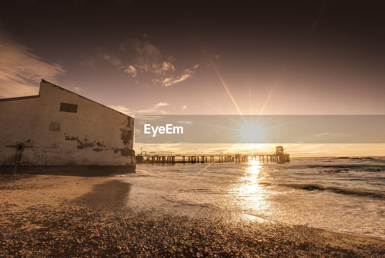 SCENIC VIEW OF BEACH AGAINST SKY AT SUNSET