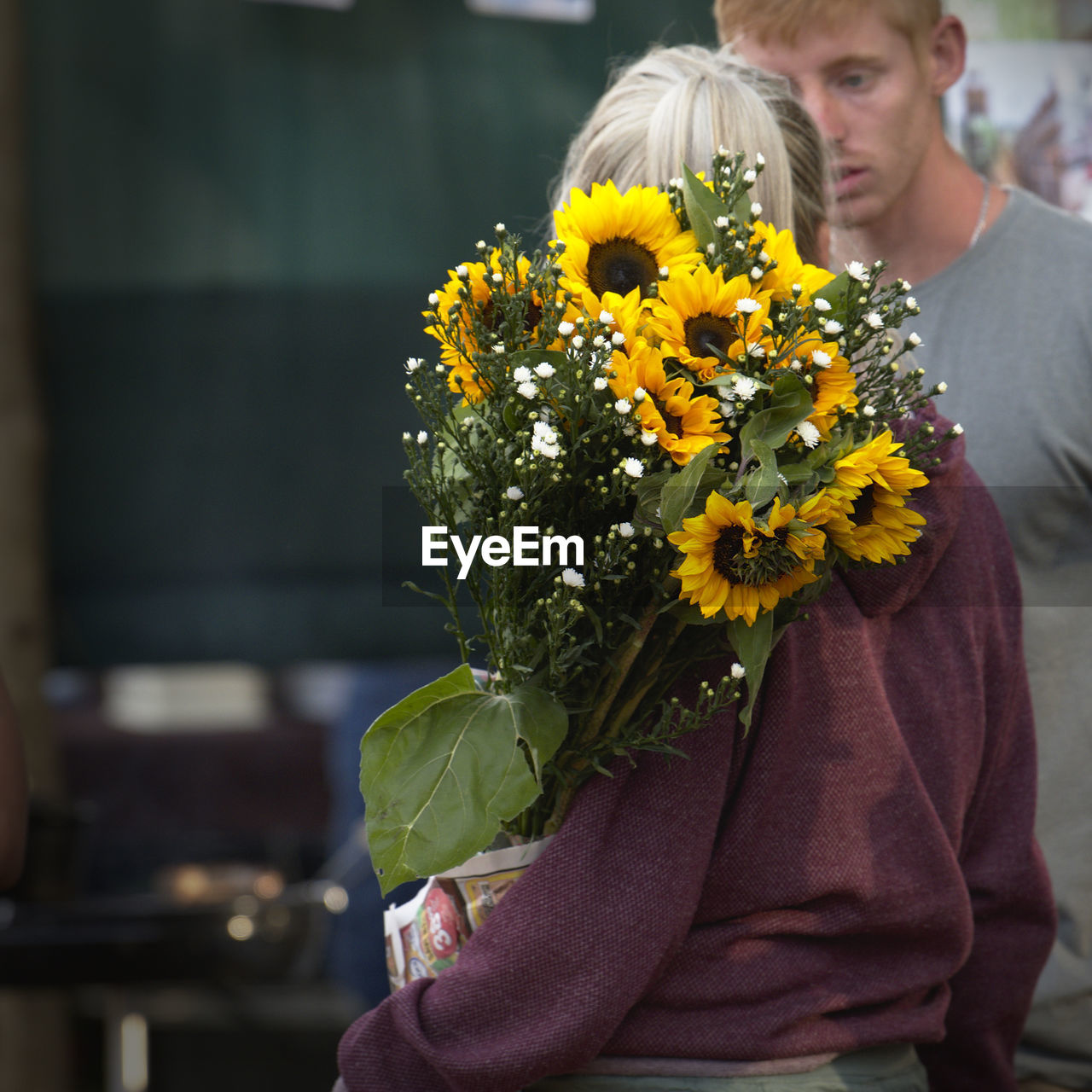 MIDSECTION OF WOMAN WITH YELLOW FLOWERS