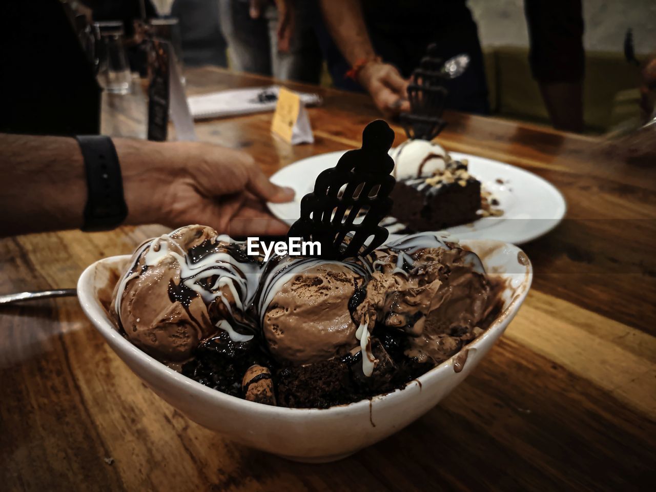 CLOSE-UP OF HAND HOLDING ICE CREAM