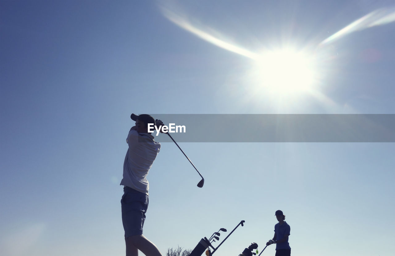 Friends playing golf clear blue sky during sunny day