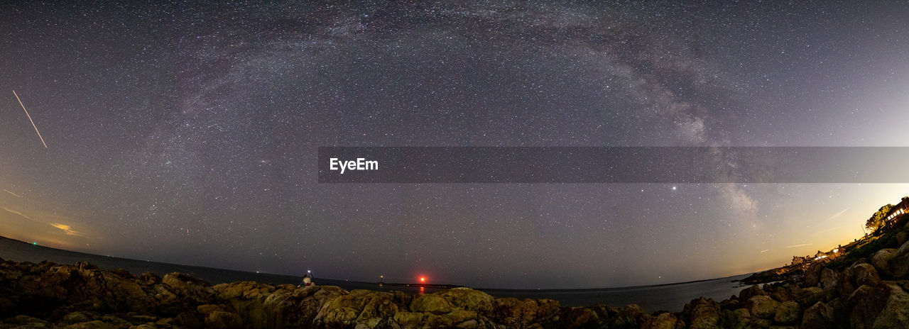 Milkyway panorama along the rocky coastline with lighthouses below.
