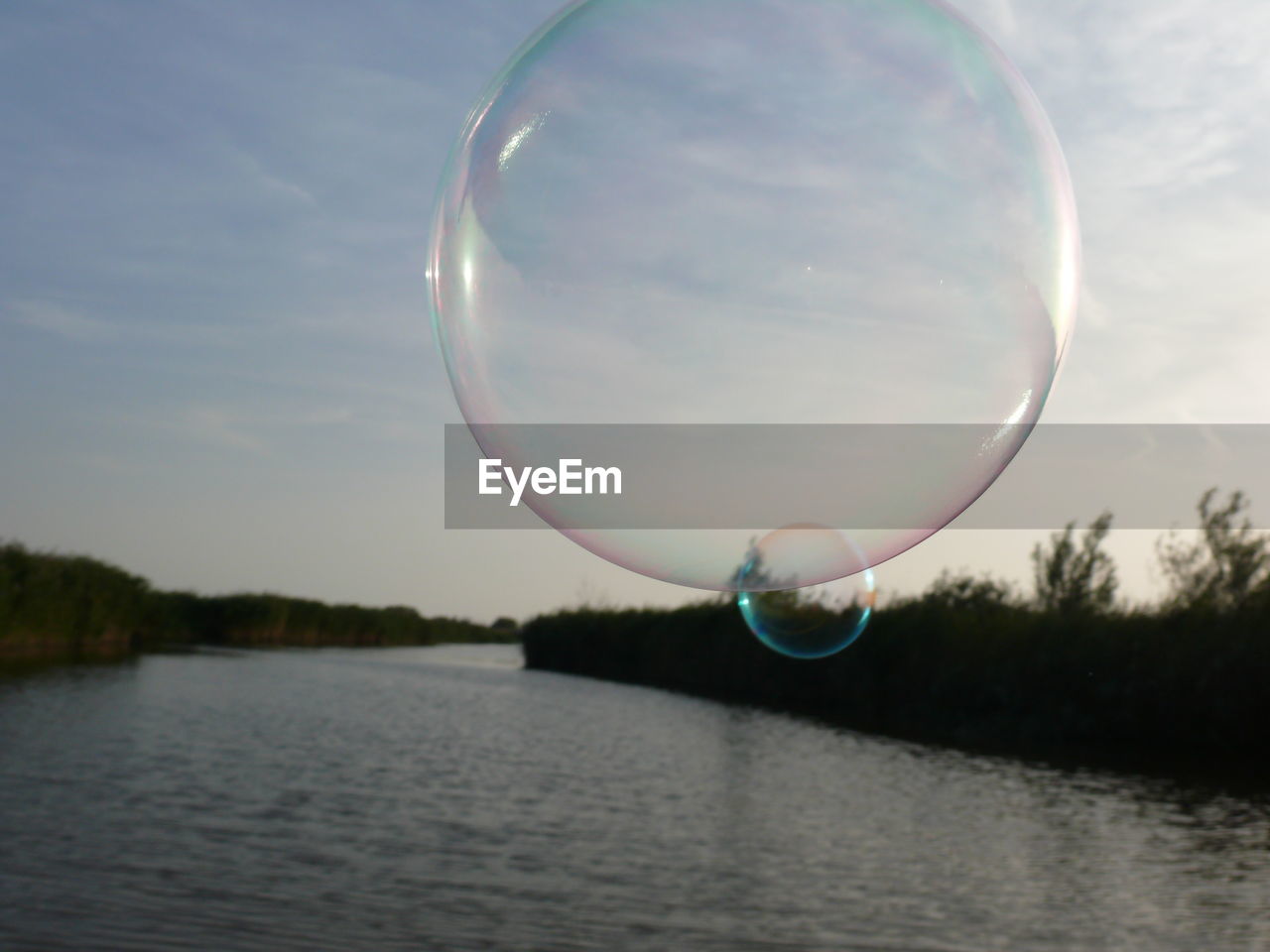 Close-up of bubble over river against sky