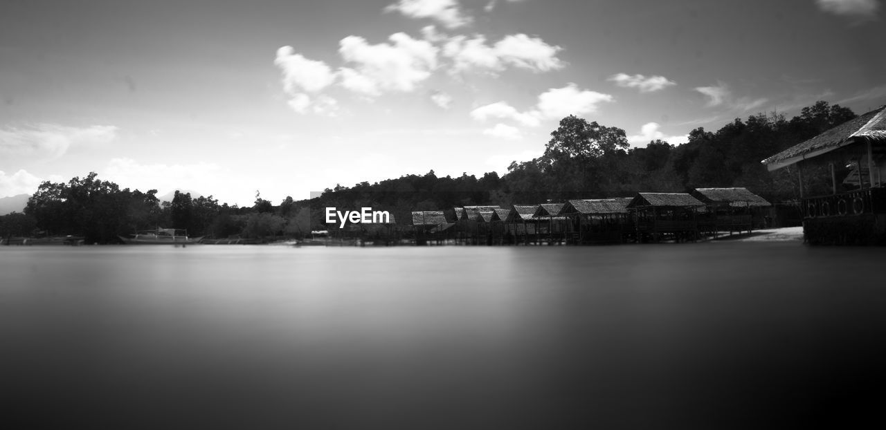 LAKE BY BUILDINGS AGAINST SKY