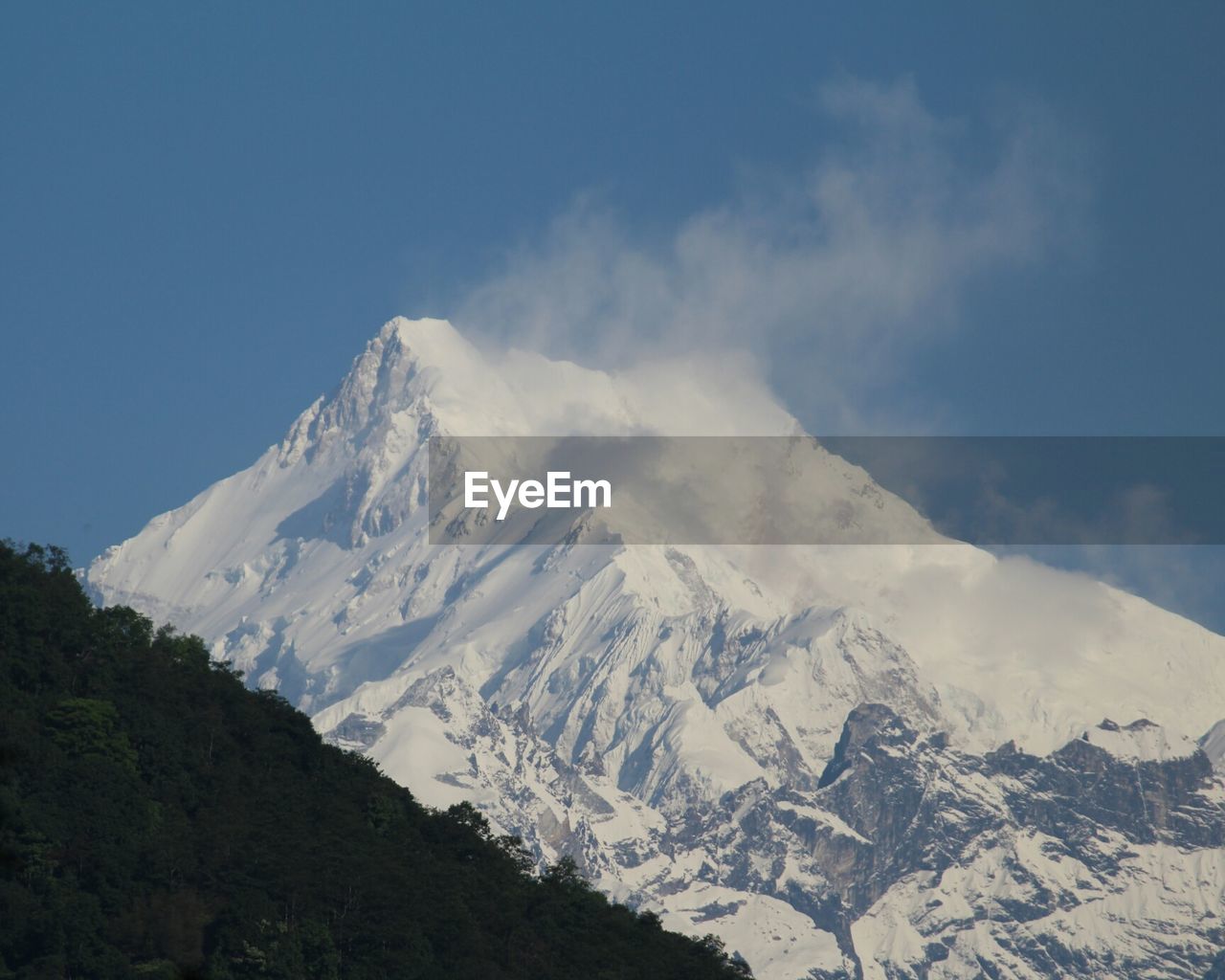 Scenic view of snowcapped mountain against clear blue sky