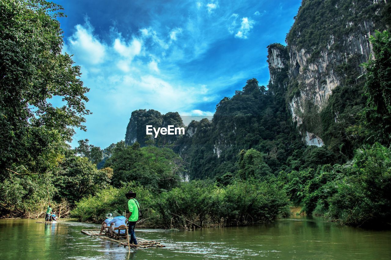 PEOPLE BY RIVER AGAINST SKY