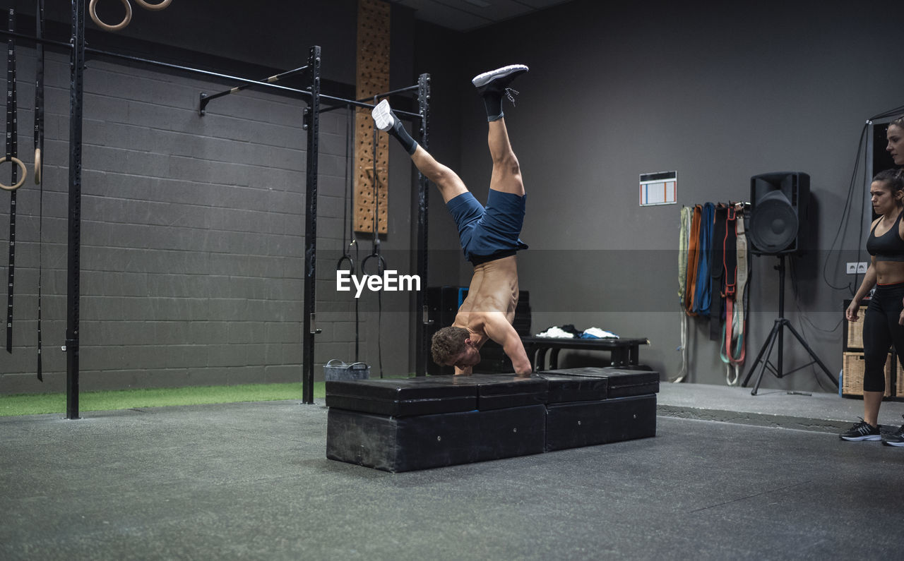 Adaptive athlete doing handstand while exercising at gym