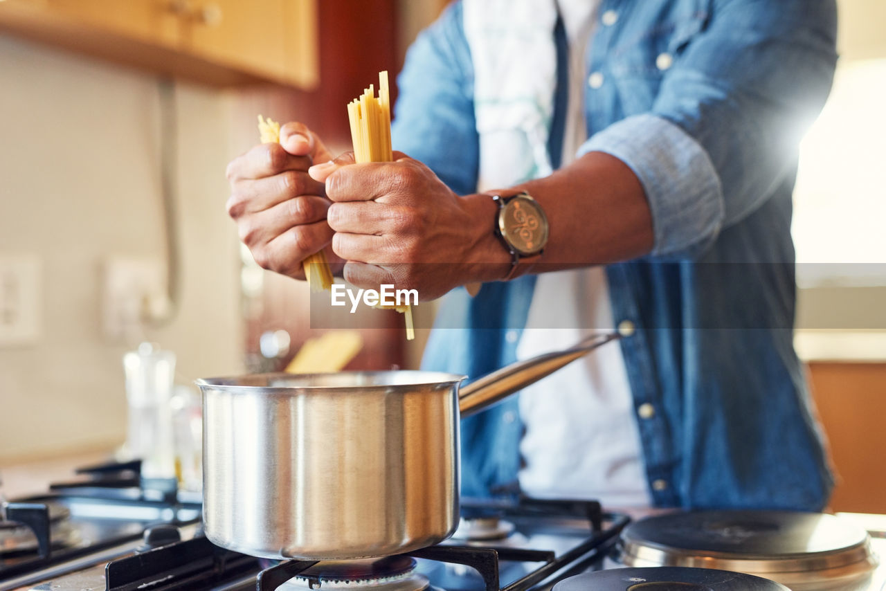 cropped hand of man preparing food in kitchen