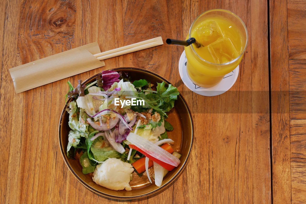 High angle view of food in container with drink on wooden table